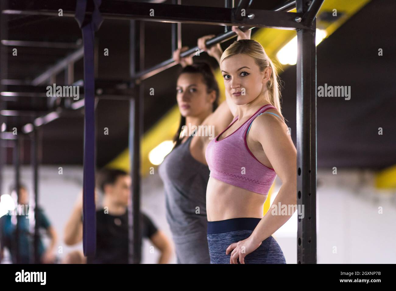 group of young muscular athletes doing pull ups on the horizontal bar ...