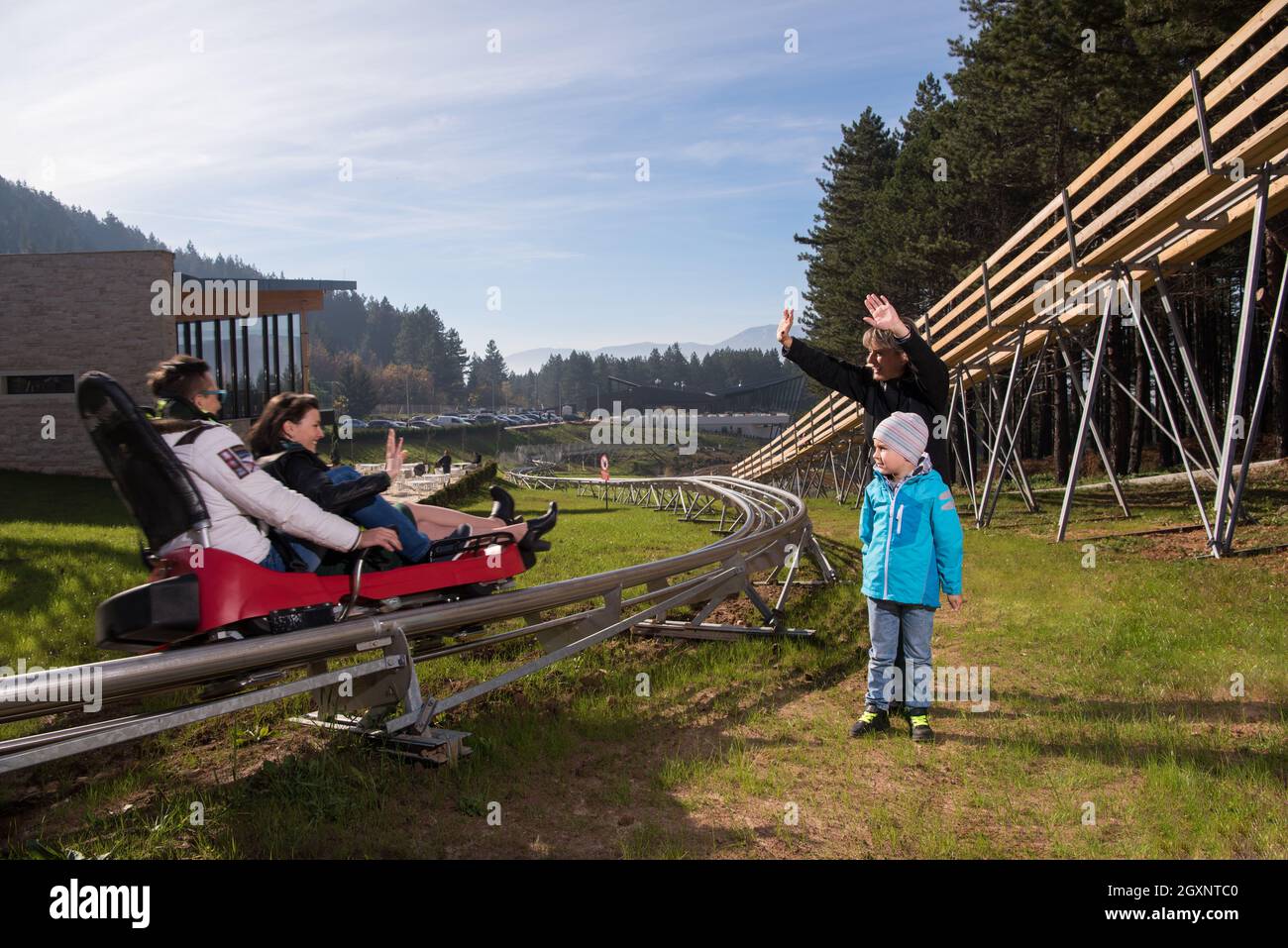 Happy family enjoys driving on alpine coaster Stock Photo Alamy