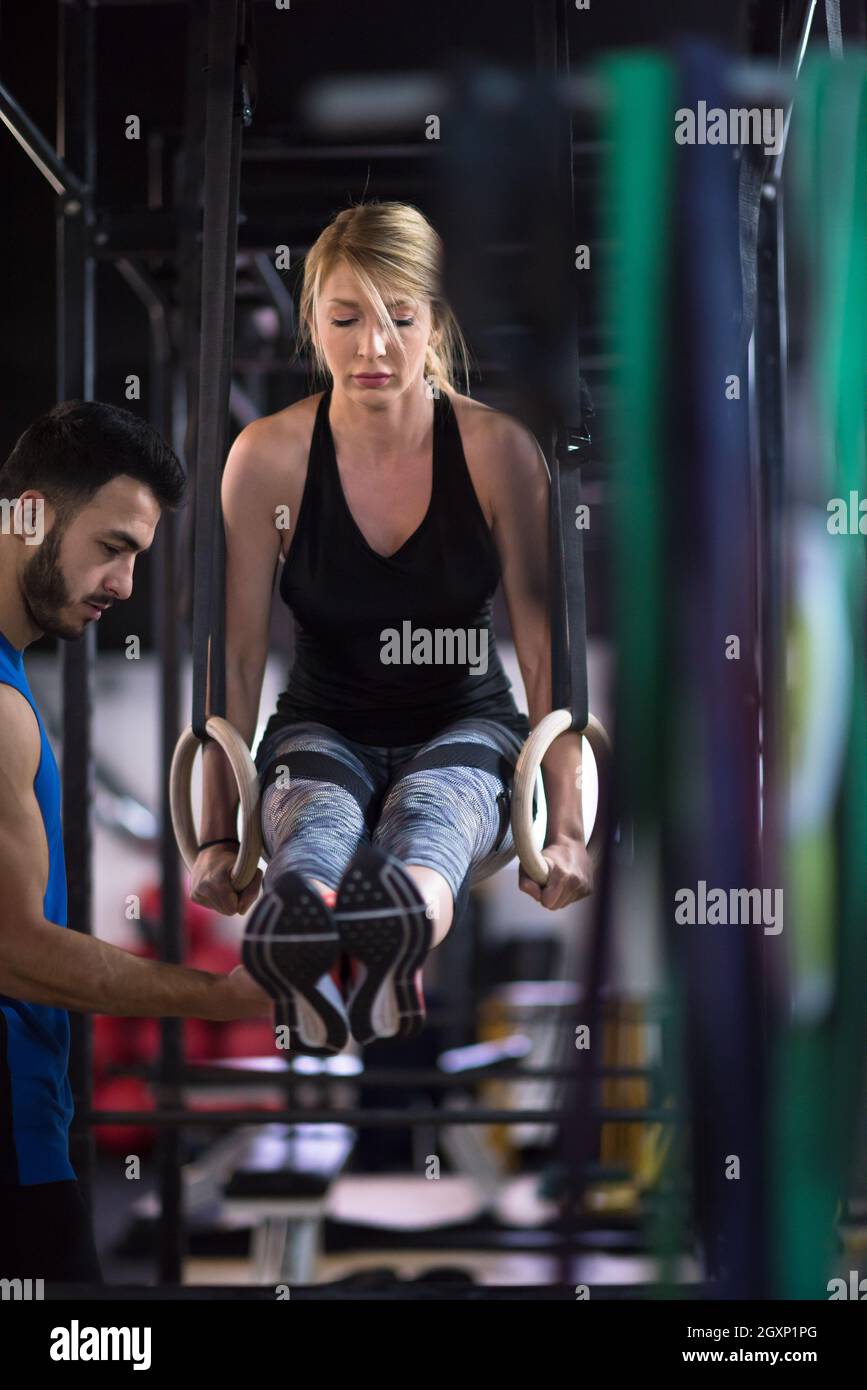 young athletic woman working out with personal trainer on gymnastic