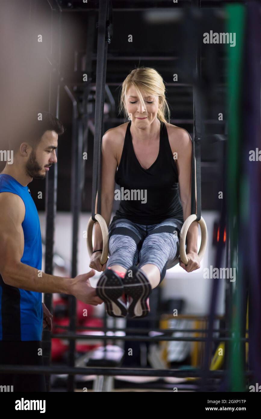 young athletic woman working out with personal trainer on gymnastic