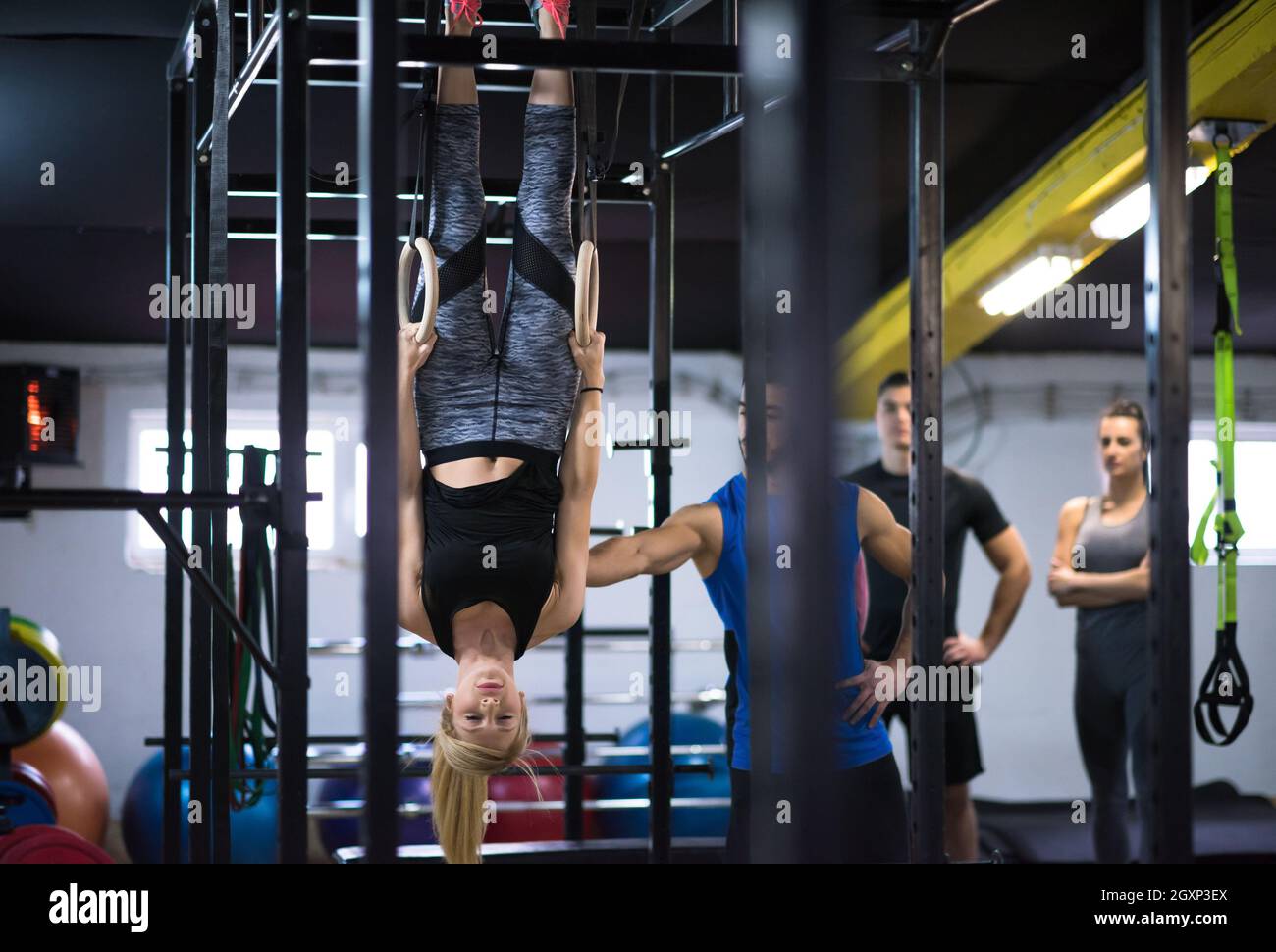 young athletic woman working out with personal trainer on gymnastic