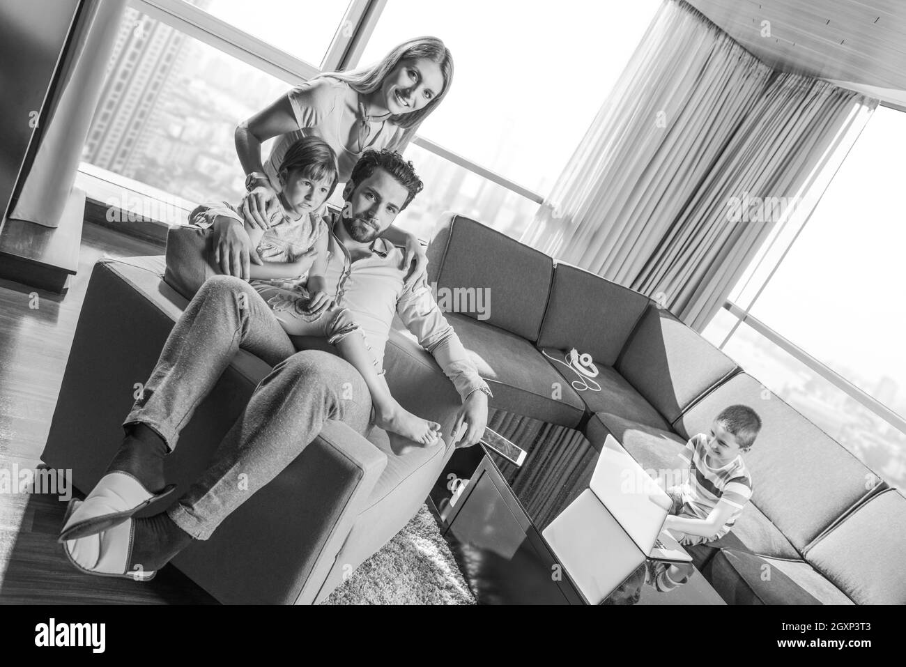 happy couple spending time with kids using tablet computer on an armchair  at home Stock Photo