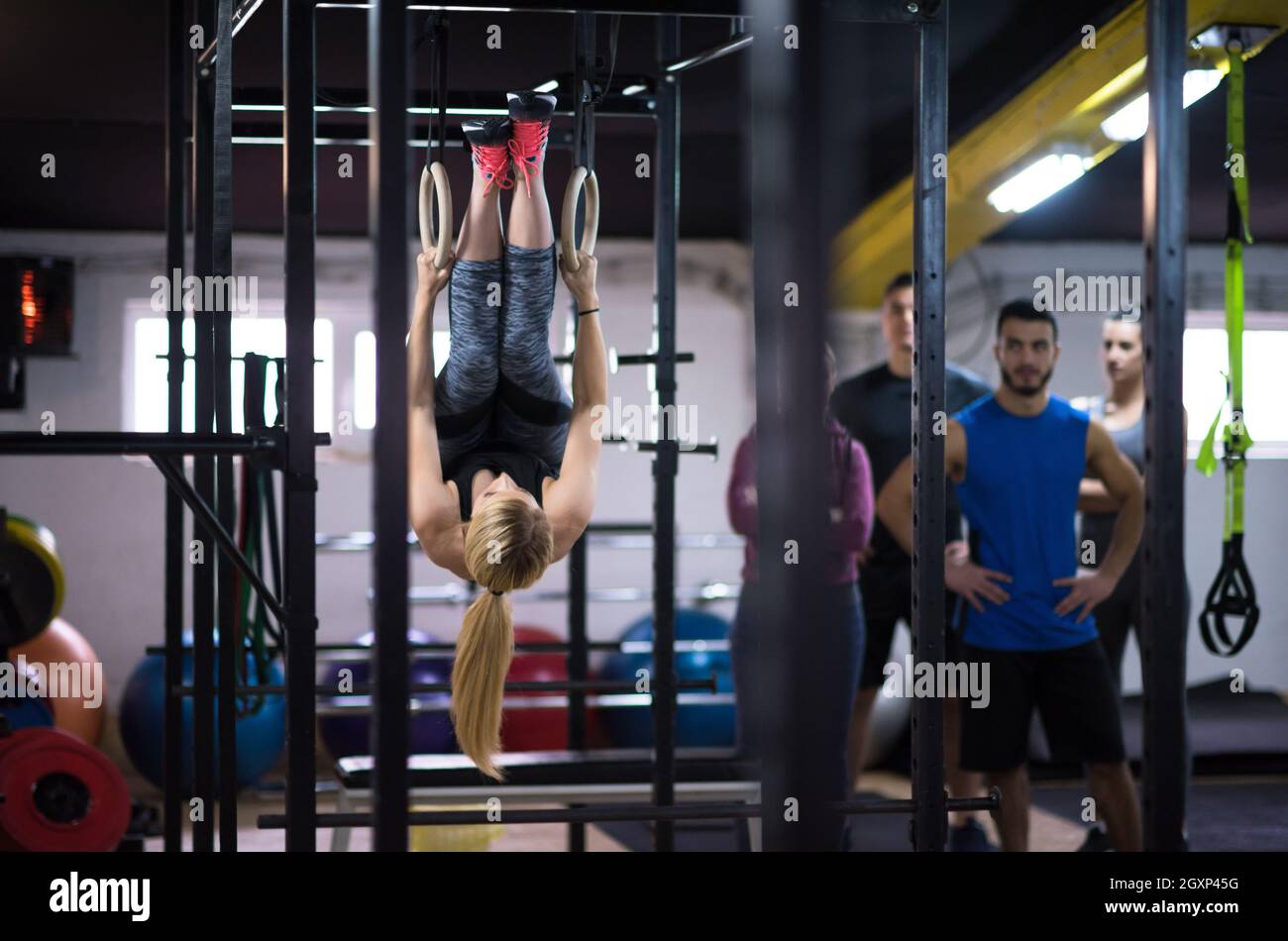 young athletic woman working out with personal trainer on gymnastic