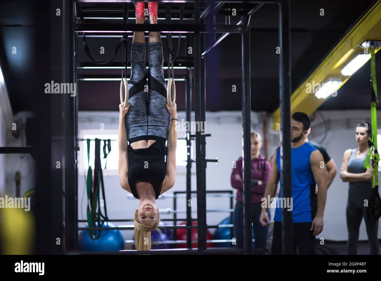 young athletic woman working out with personal trainer on gymnastic