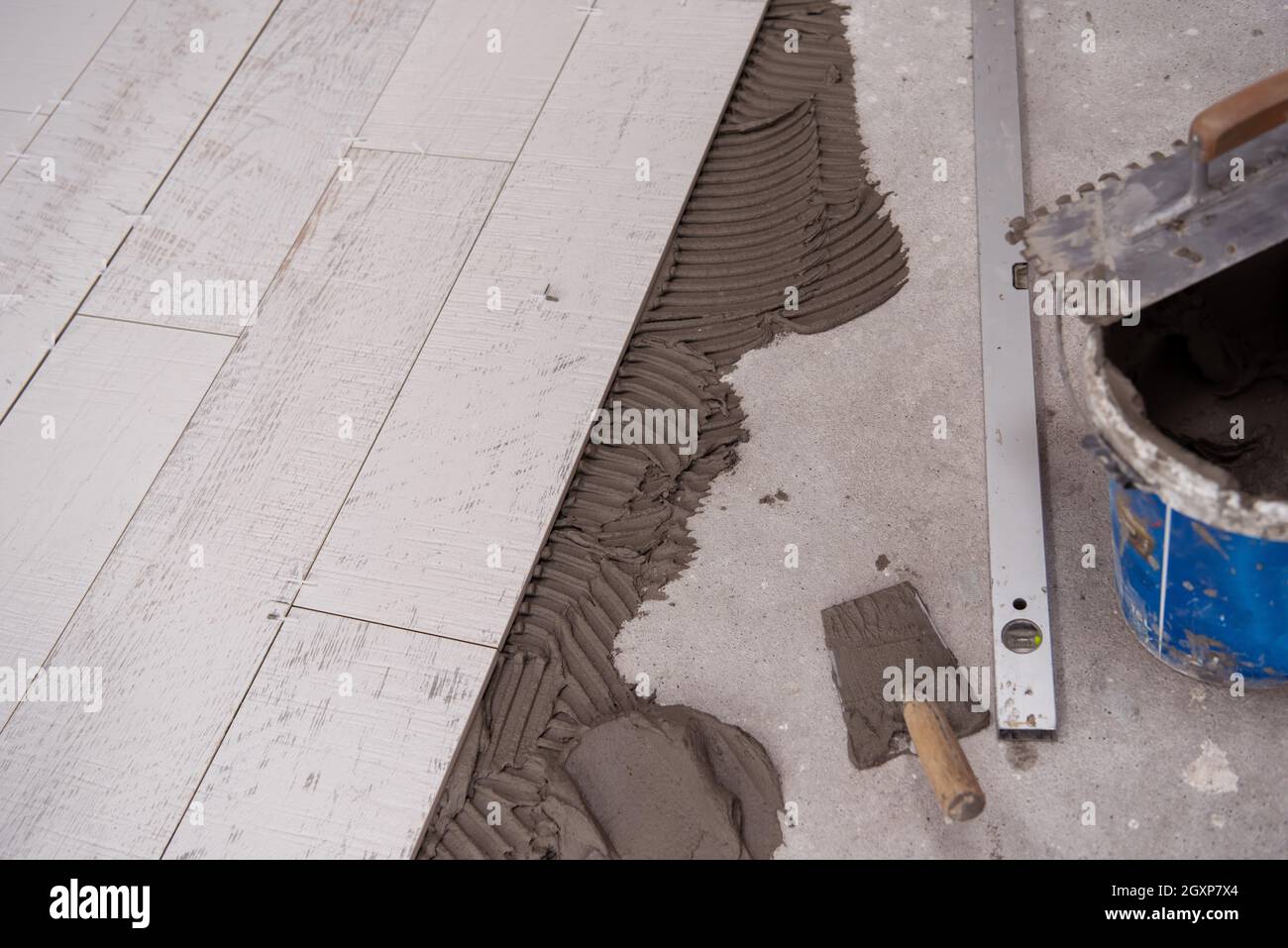 Ceramic wood effect tiles and tools for tiler on the floor unfinished