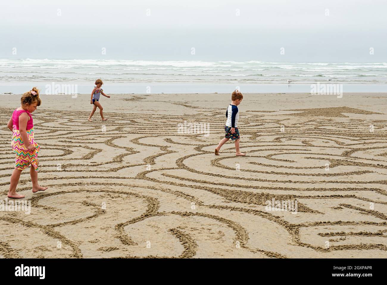 Children running through a beach maze at Cannon Beach Oregon on June 28th during the heatwave that hit the Northwestern United States. Stock Photo