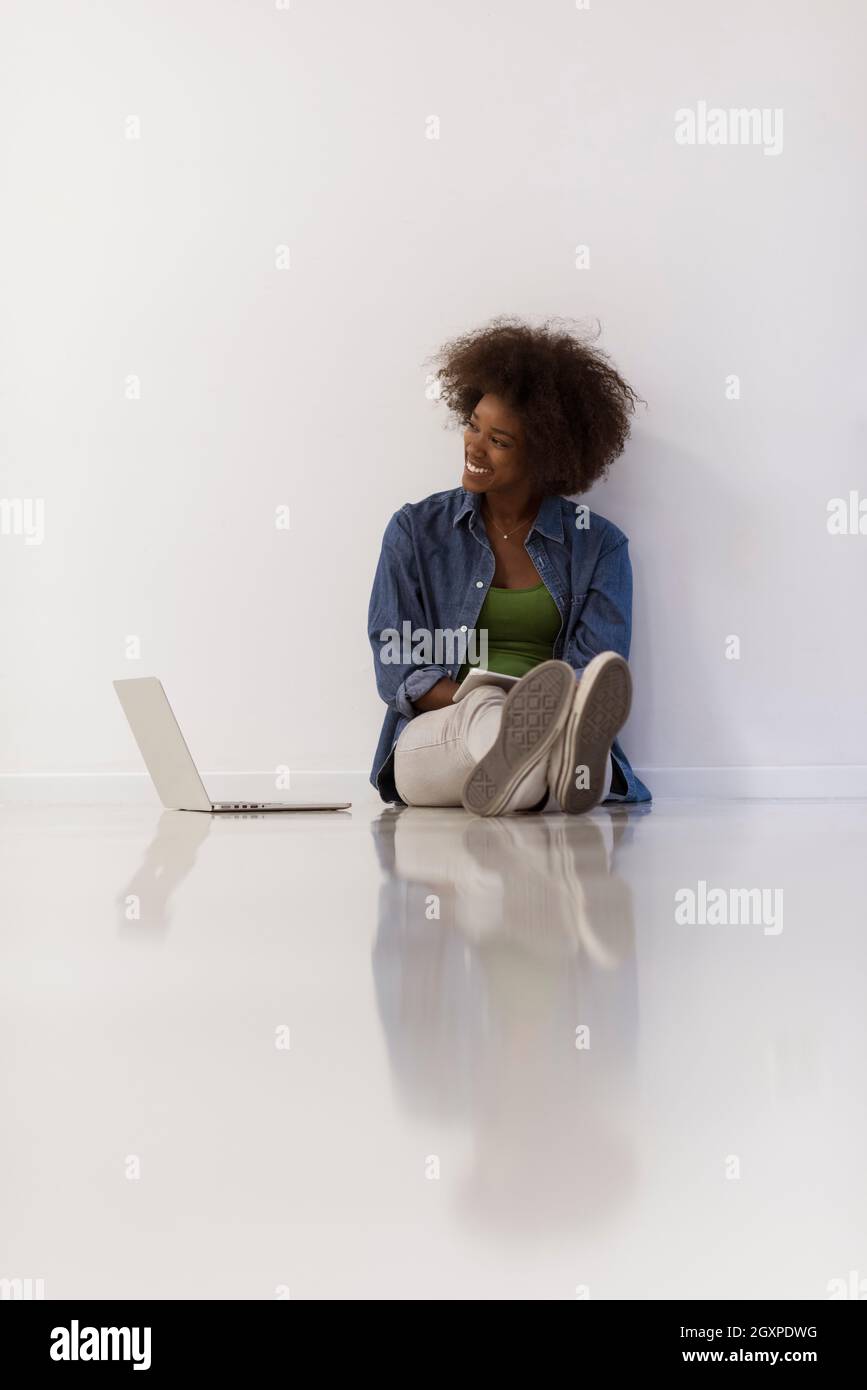 Portrait of happy young african american woman sitting on floor with ...