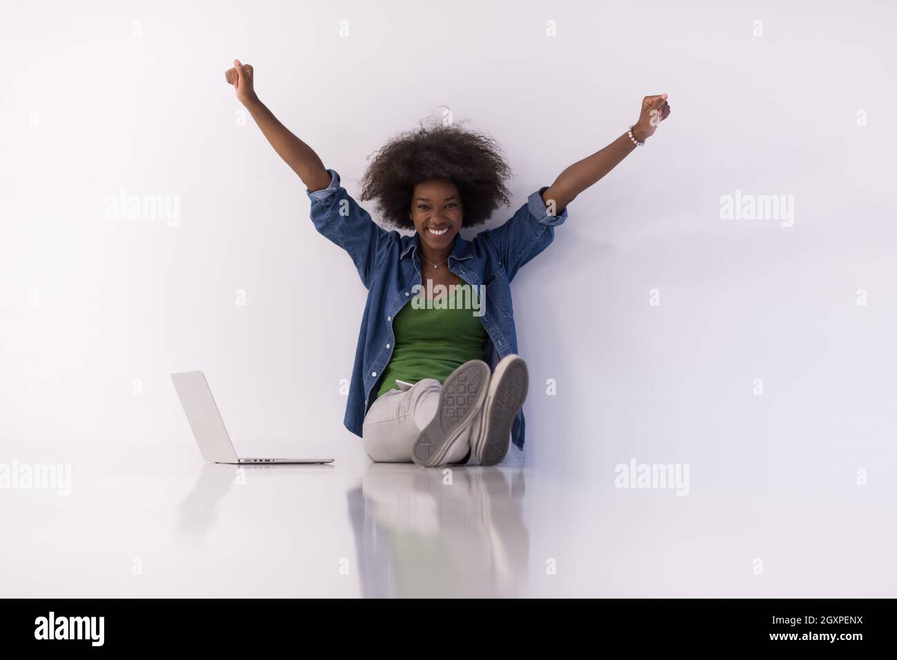 Portrait of happy young african american woman sitting on floor with ...