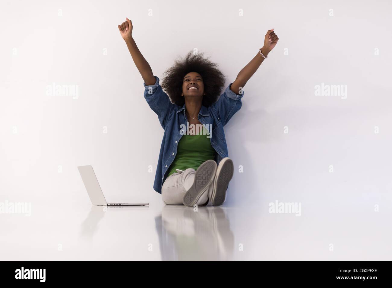 Portrait of happy young african american woman sitting on floor with ...