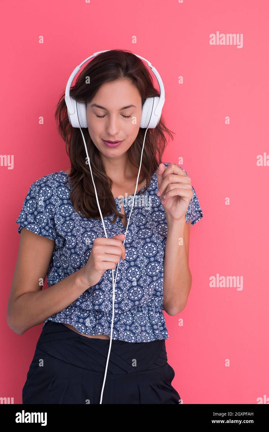 Happy young woman listening and enjoying music with headphones isolated ...