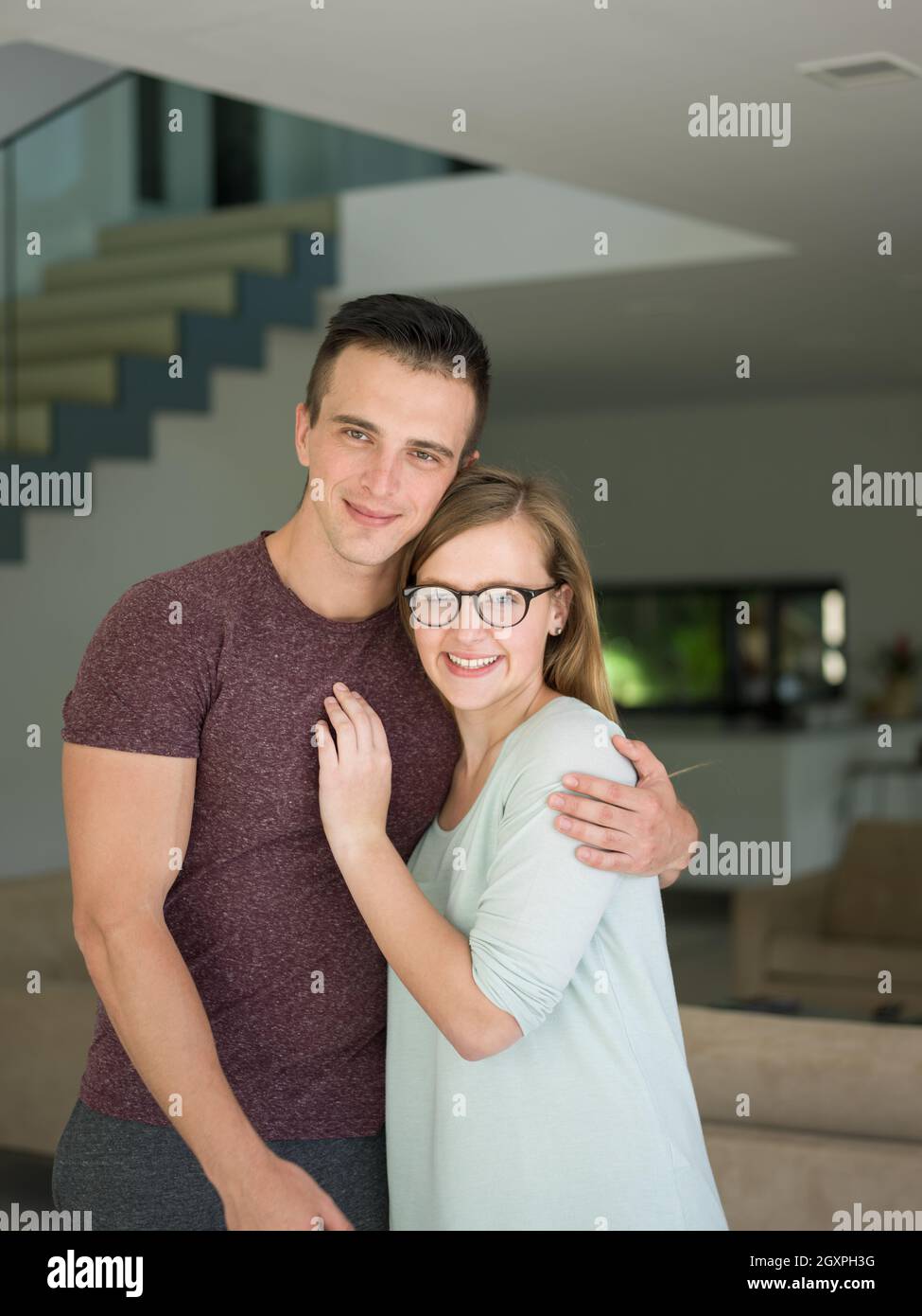 Portrait of a happy young beautiful couple hugging in their new home ...