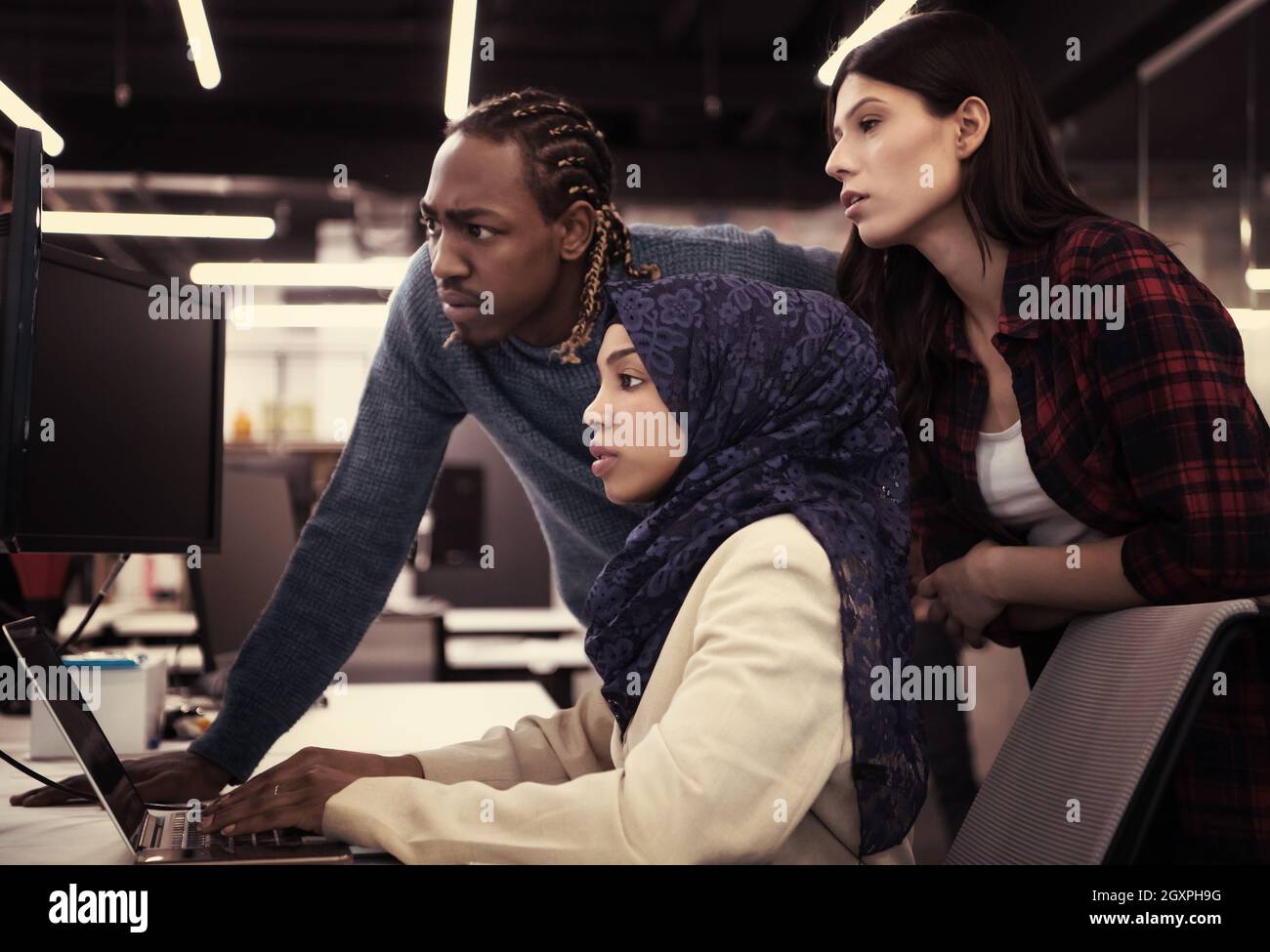 young multiethnics business team of software developers working together using laptop computer while writing programming code at modern startup office Stock Photo