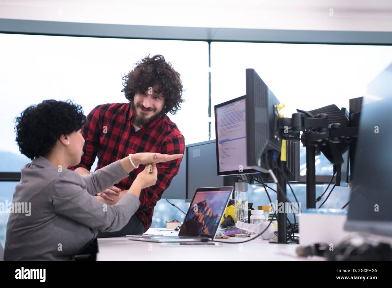 young software developers couple using laptop and desktop computer while writing programming code at modern creative startup office Stock Photo