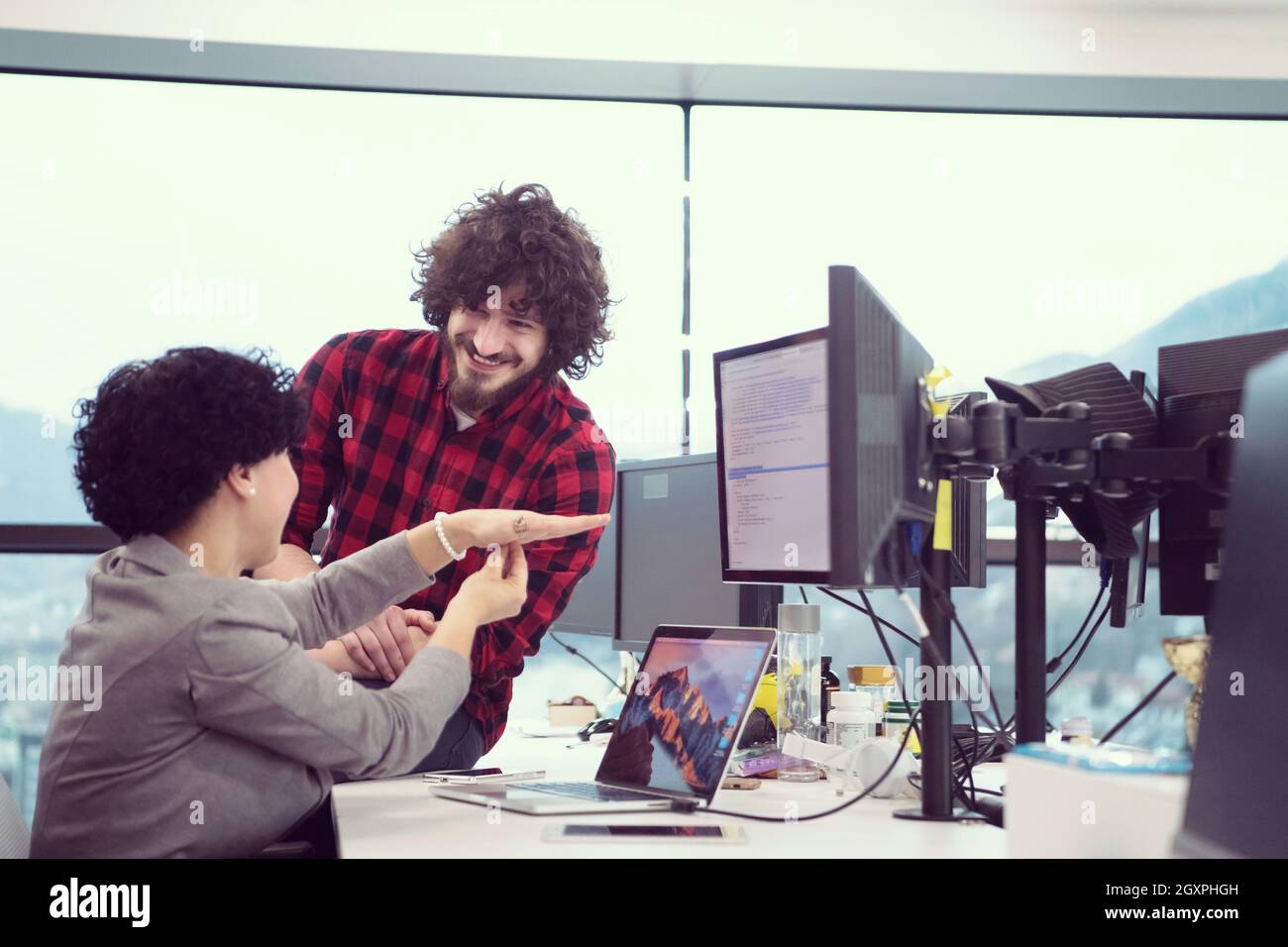 young software developers couple using laptop and desktop computer while writing programming code at modern creative startup office Stock Photo