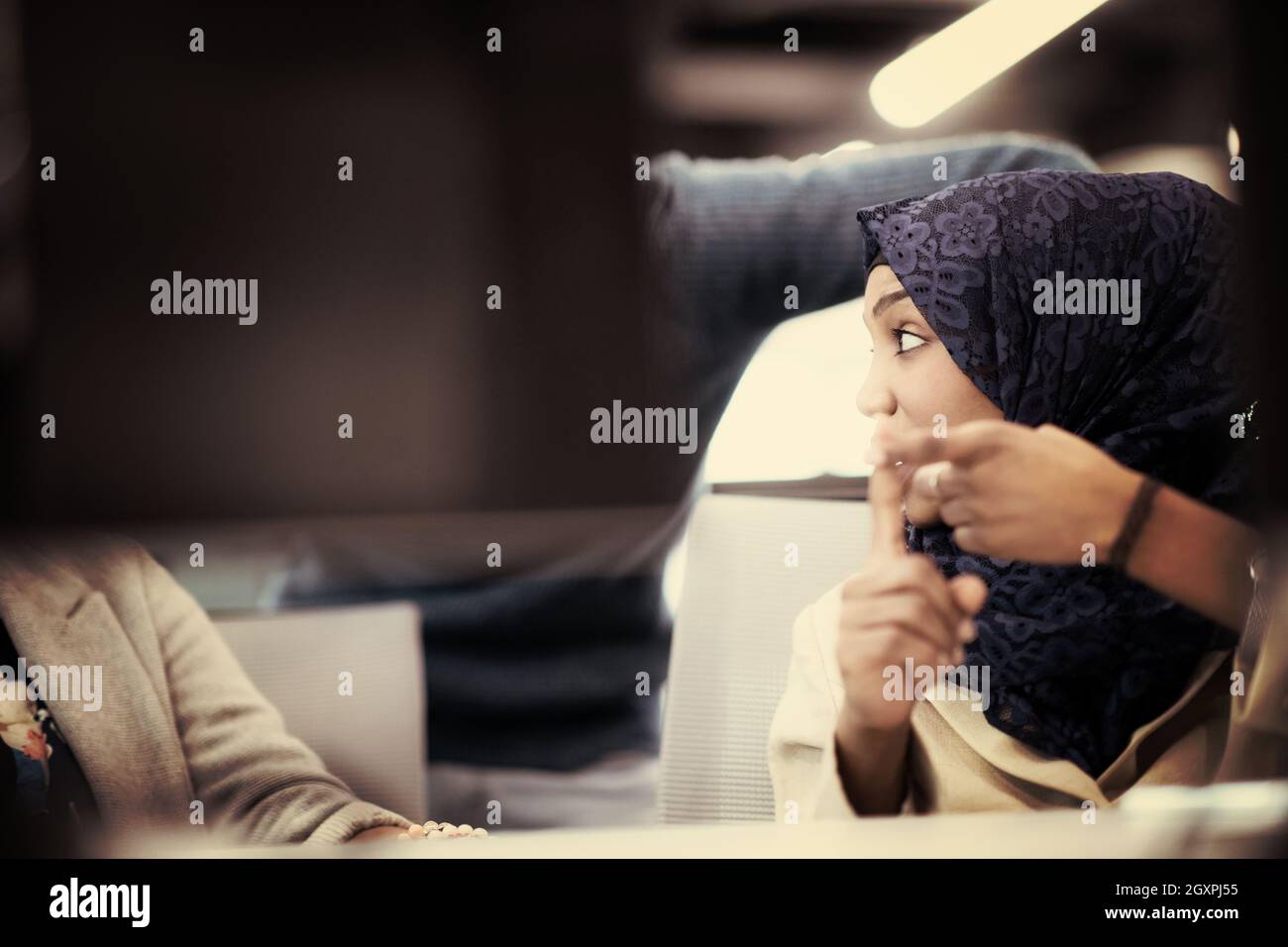 black muslim female software developer working together with her multiethnics business team using computer while writing programming code at modern st Stock Photo