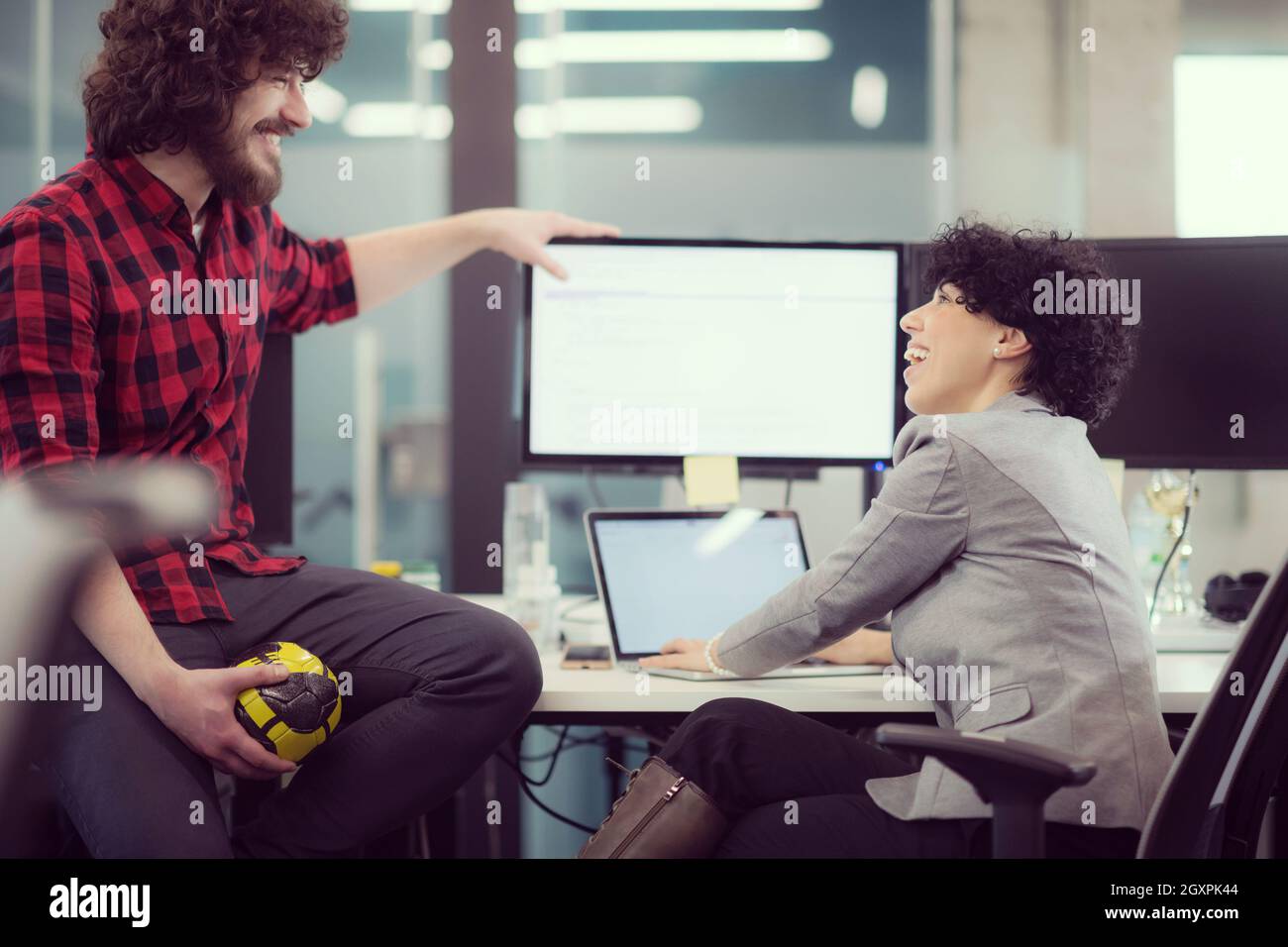 young software developers couple using laptop and desktop computer while writing programming code at modern creative startup office Stock Photo