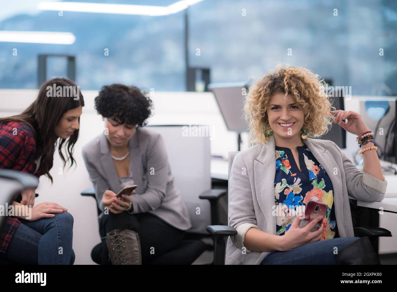 Portrait of successful female software developer with a curly hairstyle ...