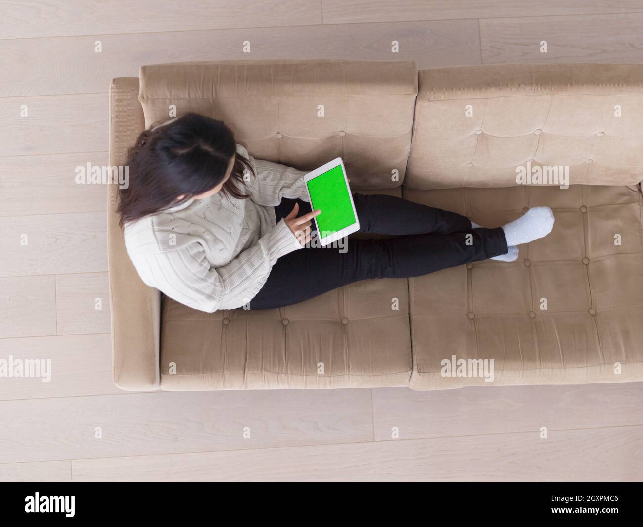 top view of young happy asian woman sitting on sofa using Digital ...