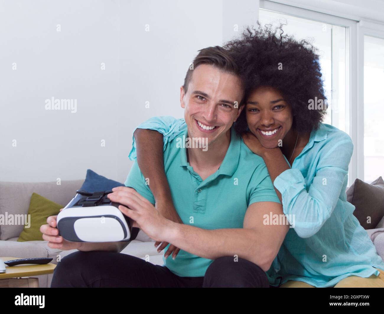 Multiethnic Couple using virtual reality headset in living room at home ...