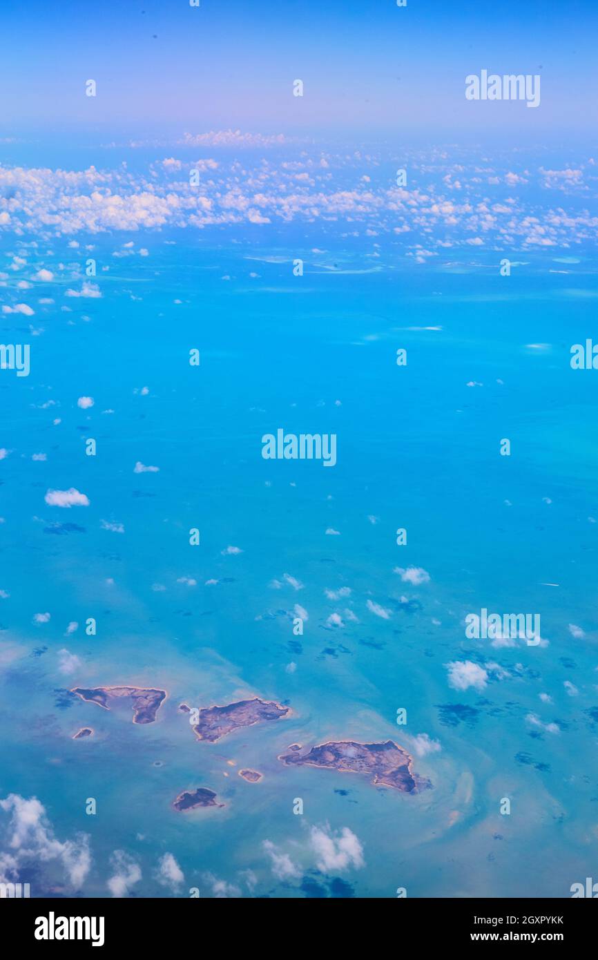 Aerial view of small islands with scattered white clouds and blue water Stock Photo