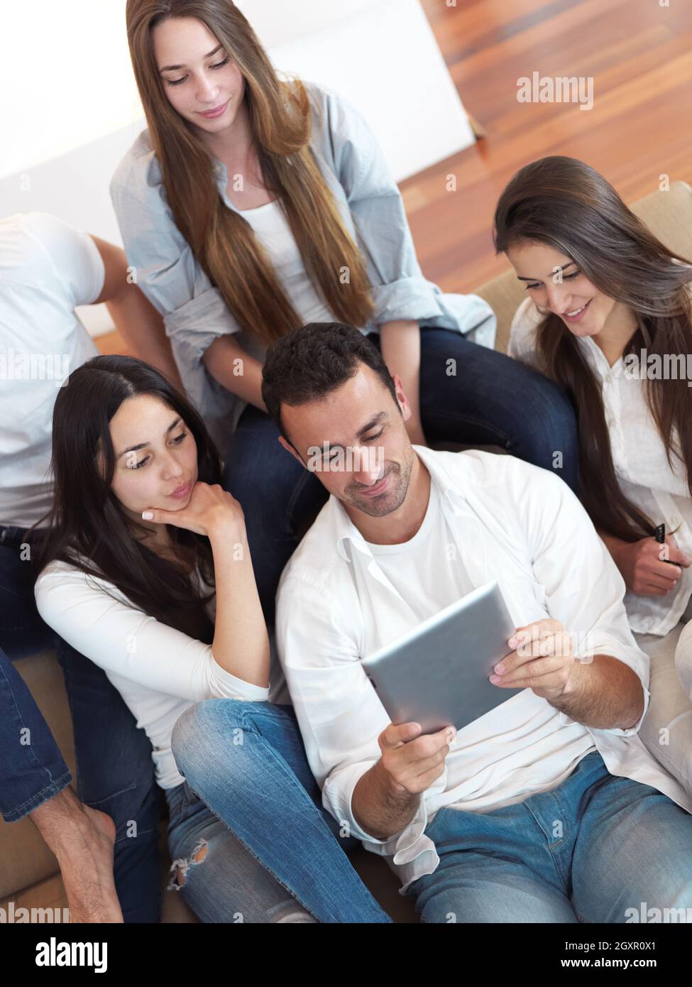 group of friends taking selfie photo with tablet at modern home indoors ...