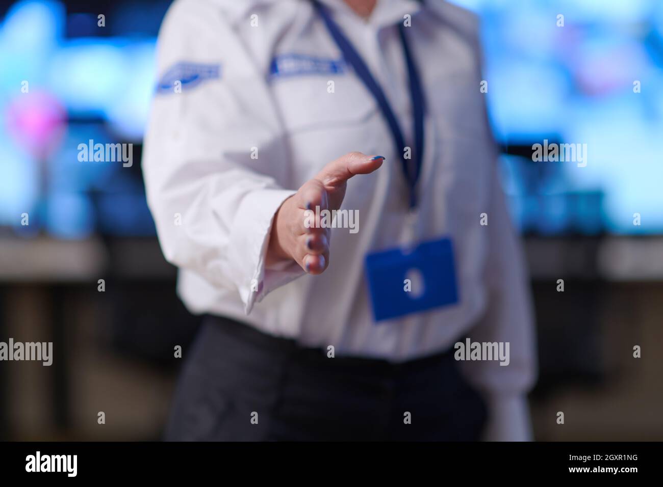 Female security operator extending a hand for a handshake while working ...