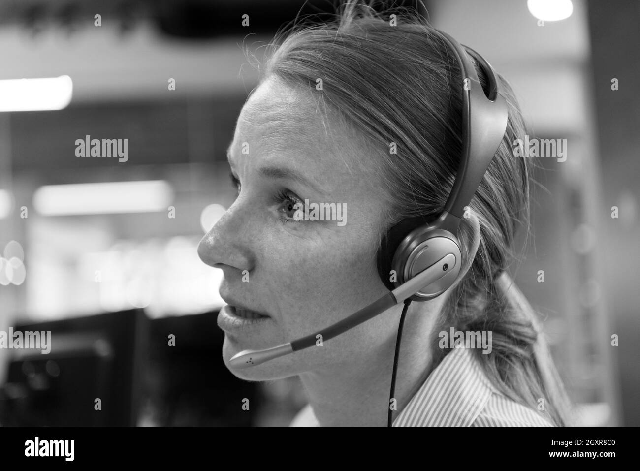 female customer support phone operator with headset at workplace Stock
