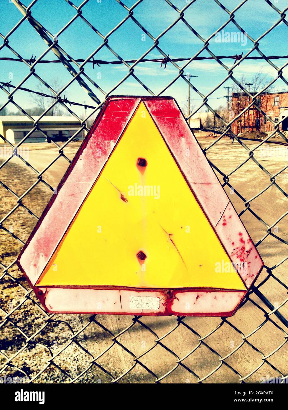 Warning sign attached to a chain link fence that guards an old ...
