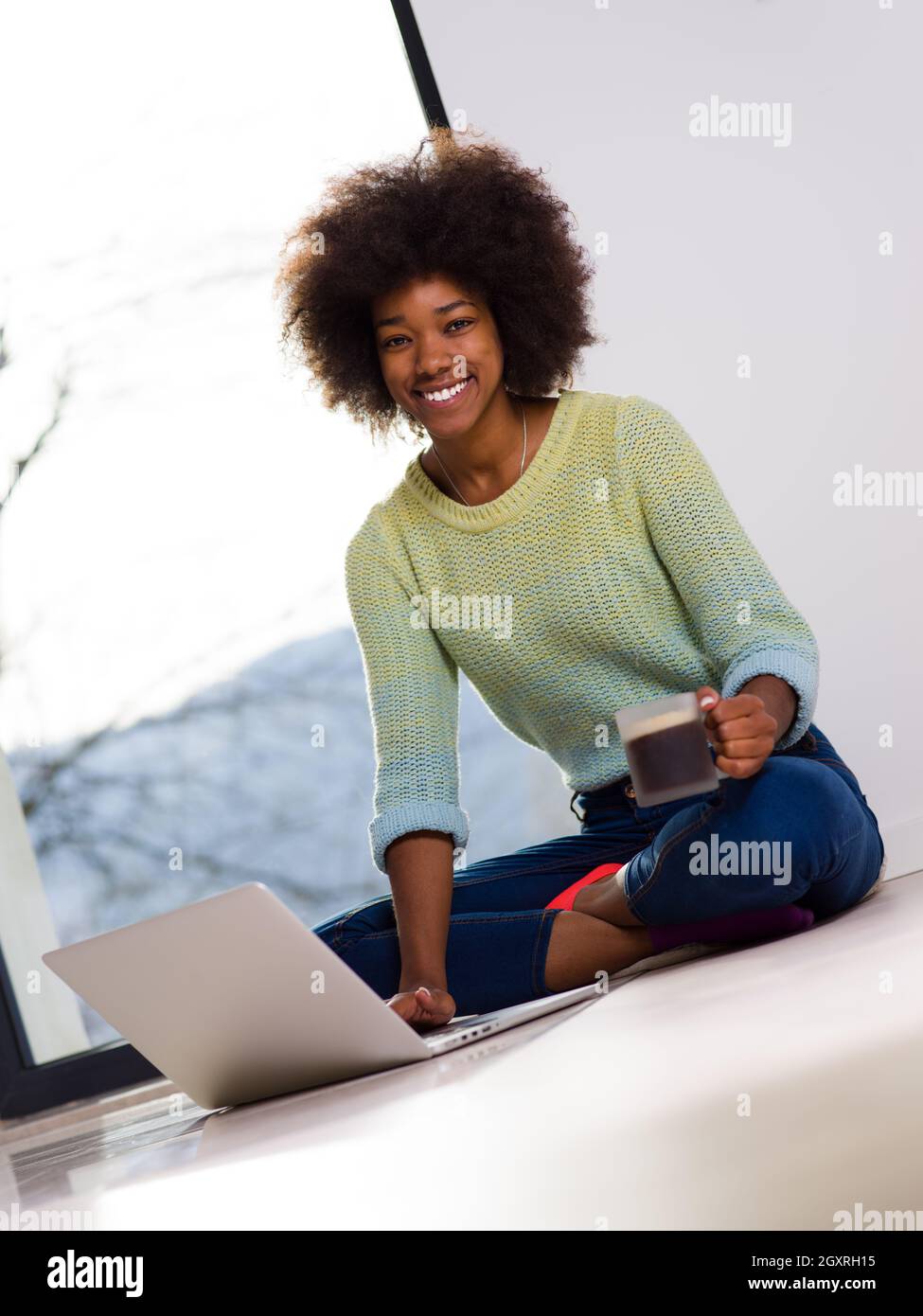 Young african american woman smiling sitting on the floor near bright ...