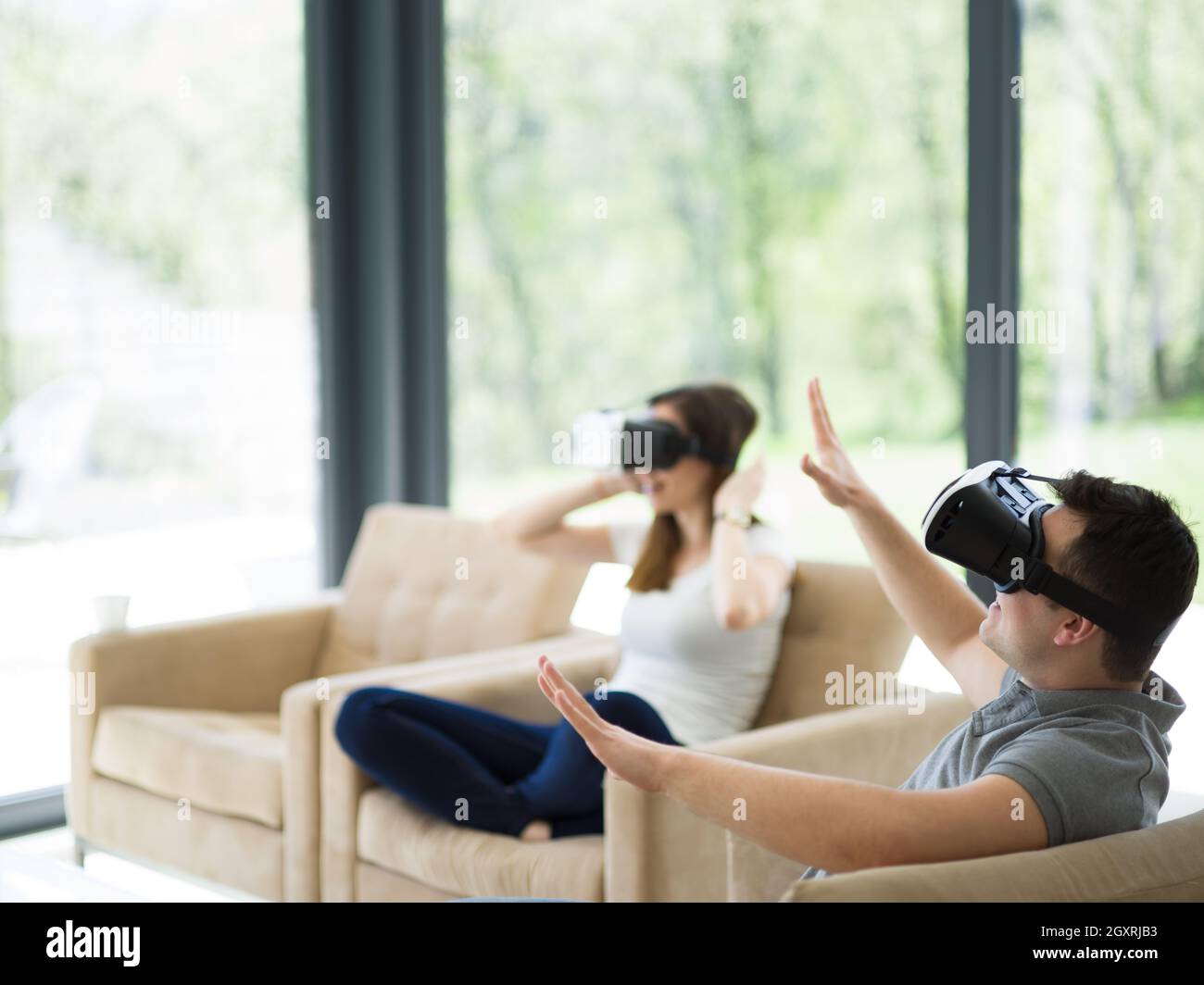 Couple using virtual reality headset in living room at home people ...