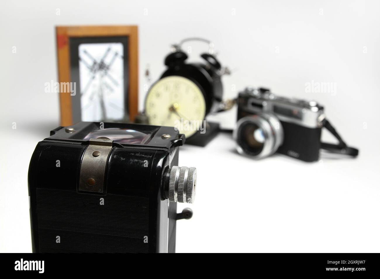 Still life of old camera with photo frame, old alarm clock, and old camera out of focus in the background Stock Photo