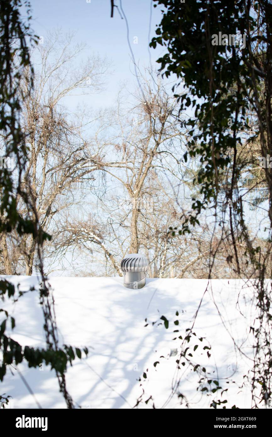 Vines framing a snowcovered roof and a whirlybird vent Stock Photo Alamy