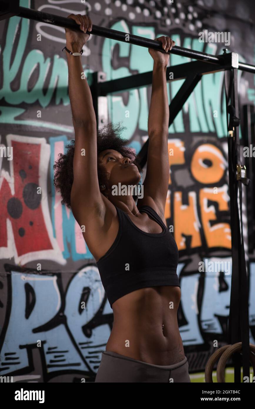 young beautiful african american woman athlete doing pull ups on the ...