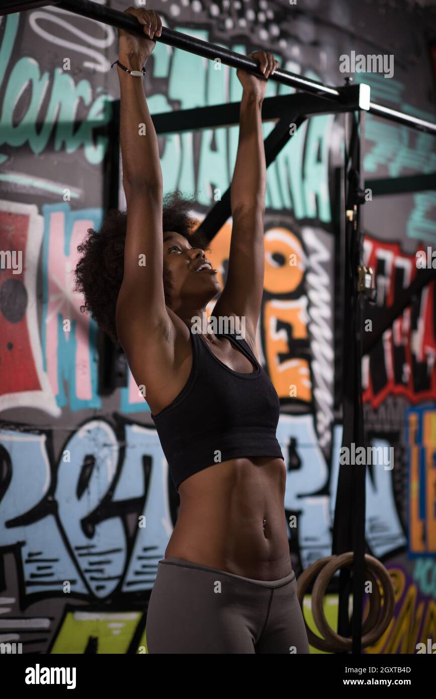 young beautiful african american woman athlete doing pull ups on the ...
