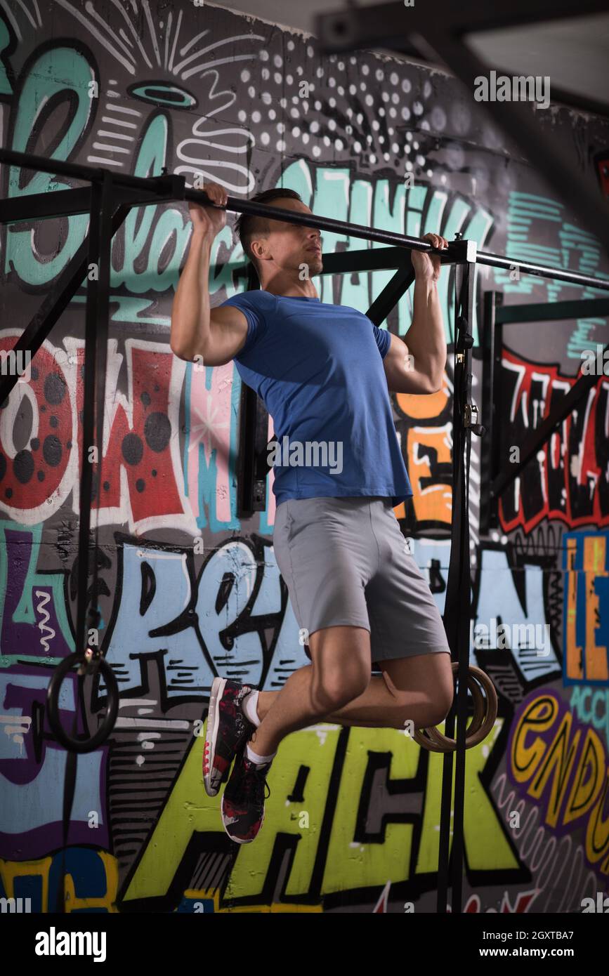 strong young man doing pull ups on a bar in a gym Stock Photo - Alamy