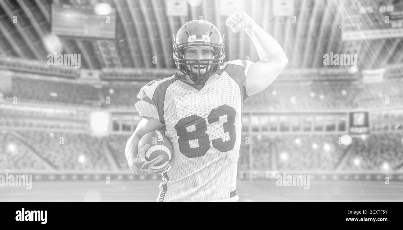 american football player celebrating touchdown on big modern stadium field with lights and flares Stock Photo