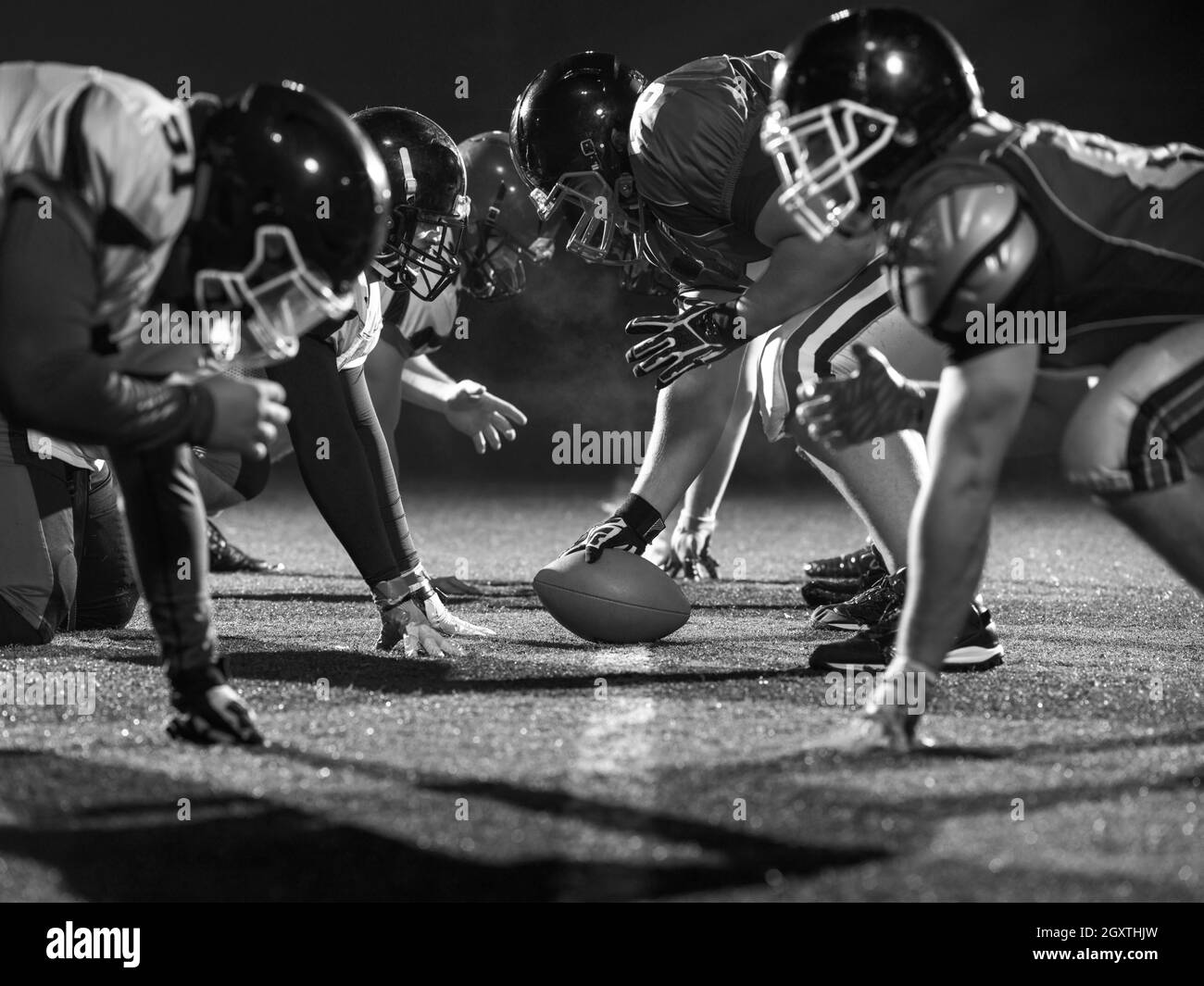 american football players are ready to start on field at night Stock Photo