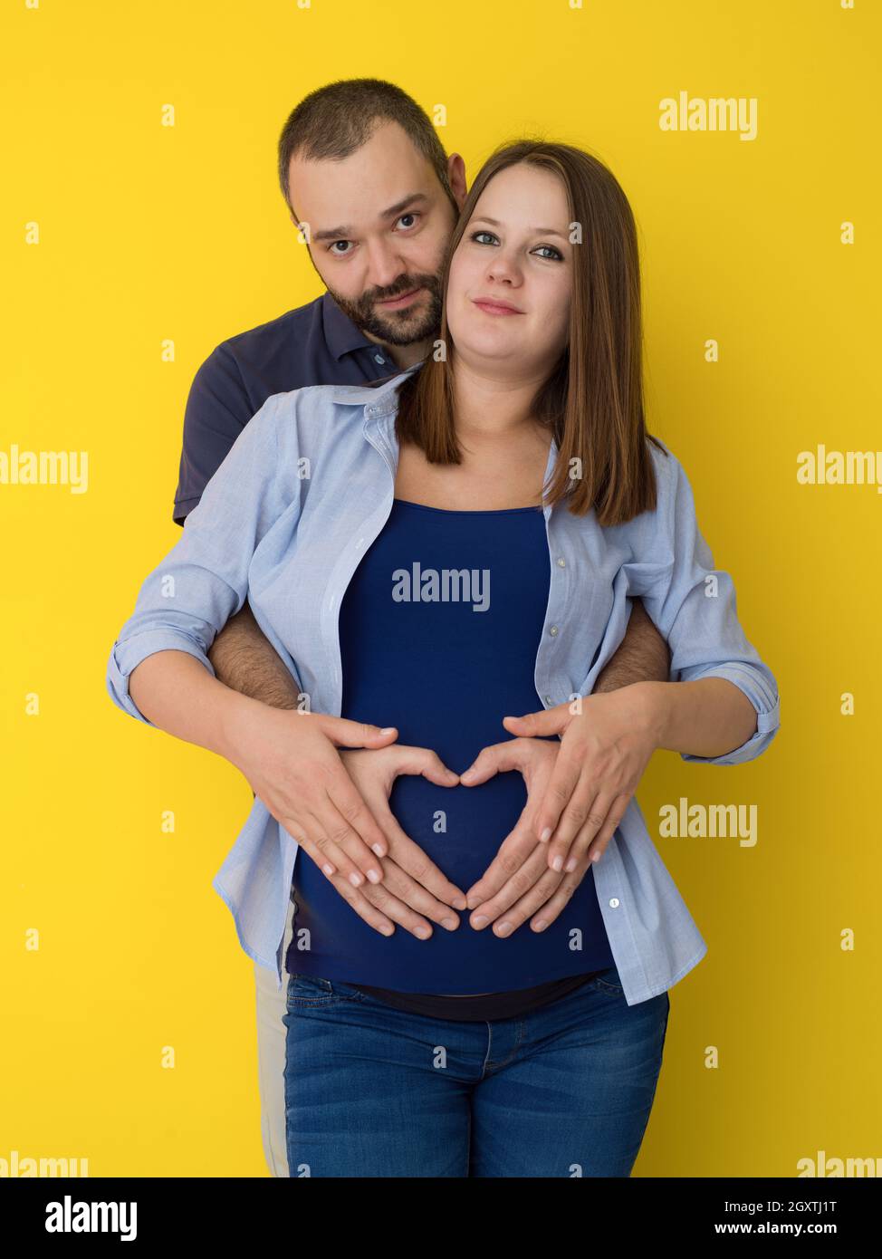 Portrait Of A Happy Young Couple Man Holding His Pregnant Wife Belly