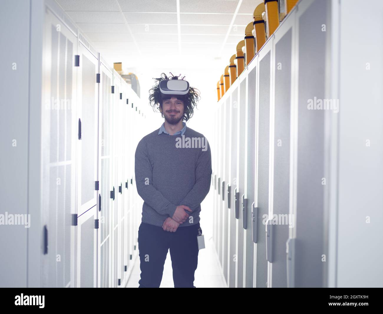 young IT engeneer using virtual reality headset over server room background Stock Photo
