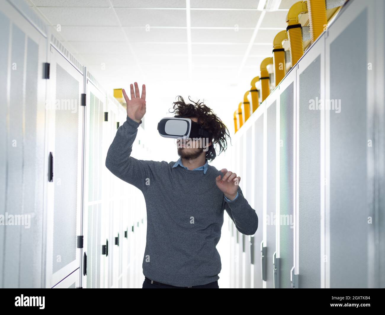 young IT engeneer using virtual reality headset over server room background Stock Photo