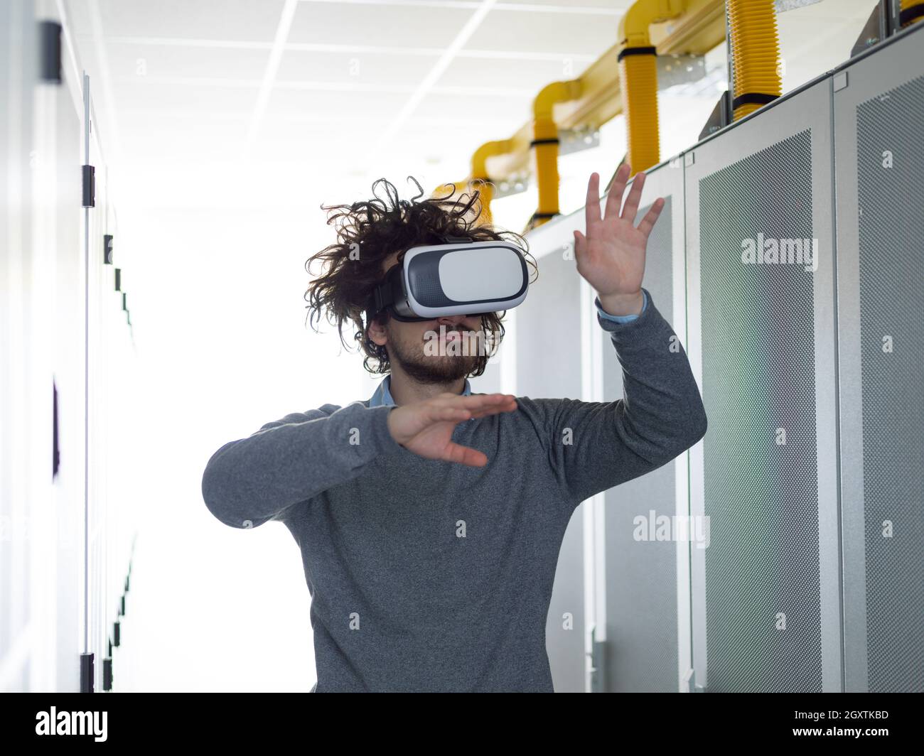 young IT engeneer using virtual reality headset over server room background Stock Photo