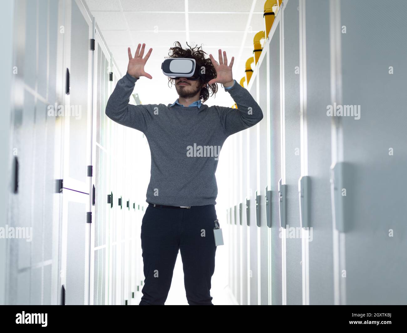 young IT engeneer using virtual reality headset over server room background Stock Photo