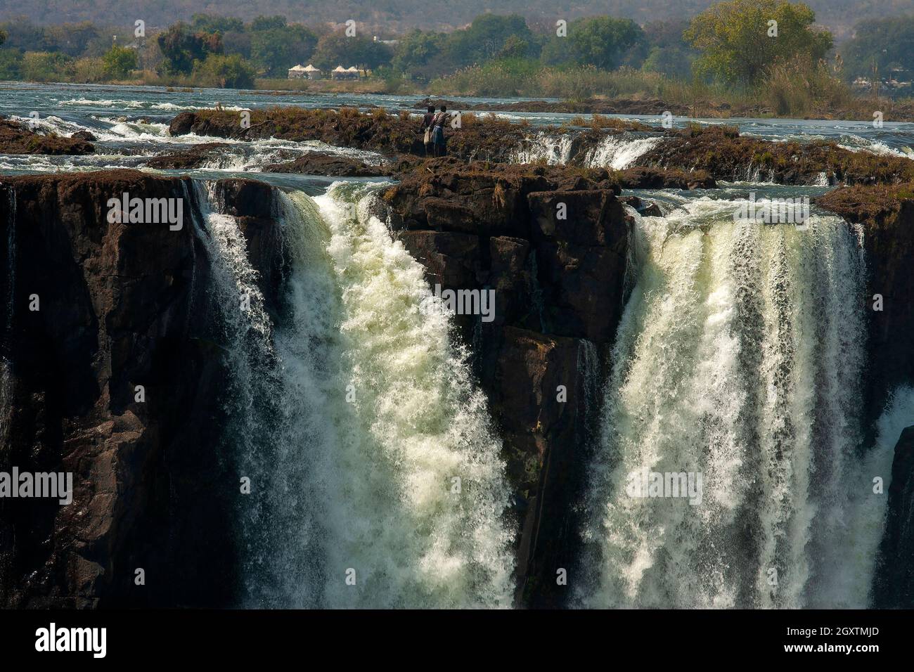 African people fishing on the headwaters of the mighty Victoria Falls on Zambezi river, just on the border of Zâmbia and Zimbabwe Stock Photo