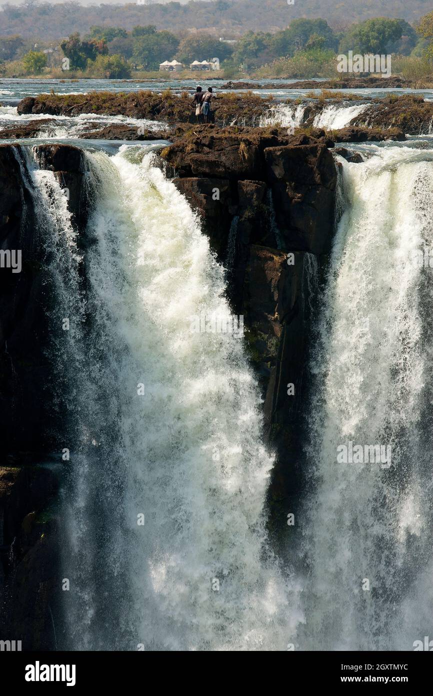 African people fishing on the headwaters of the mighty Victoria Falls on Zambezi river, just on the border of Zâmbia and Zimbabwe Stock Photo