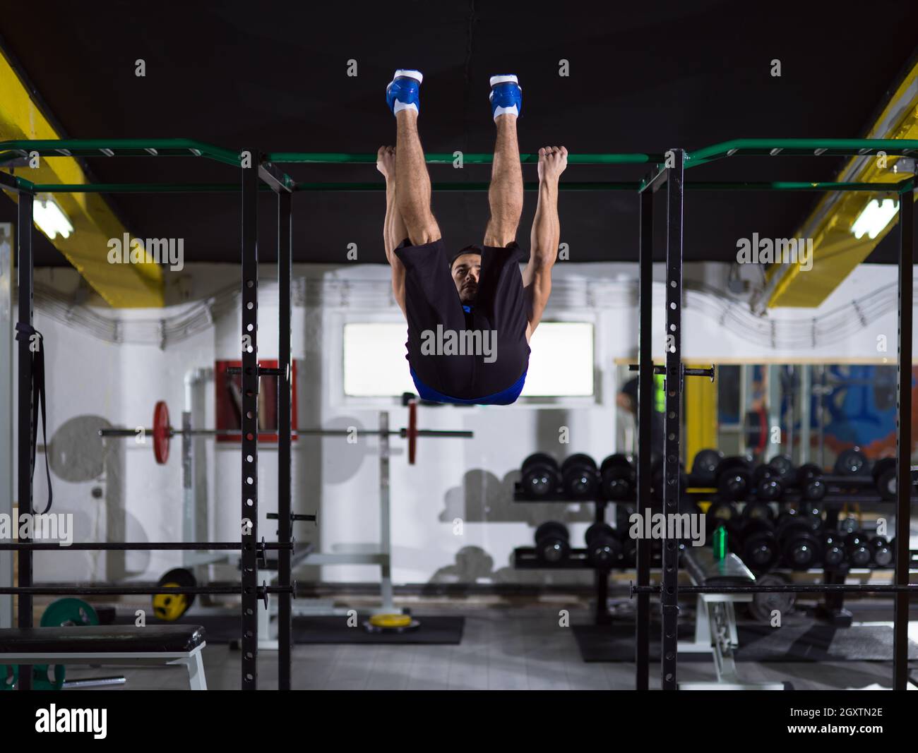 young muscular man doing pull ups on the horizontal bar as part of ...
