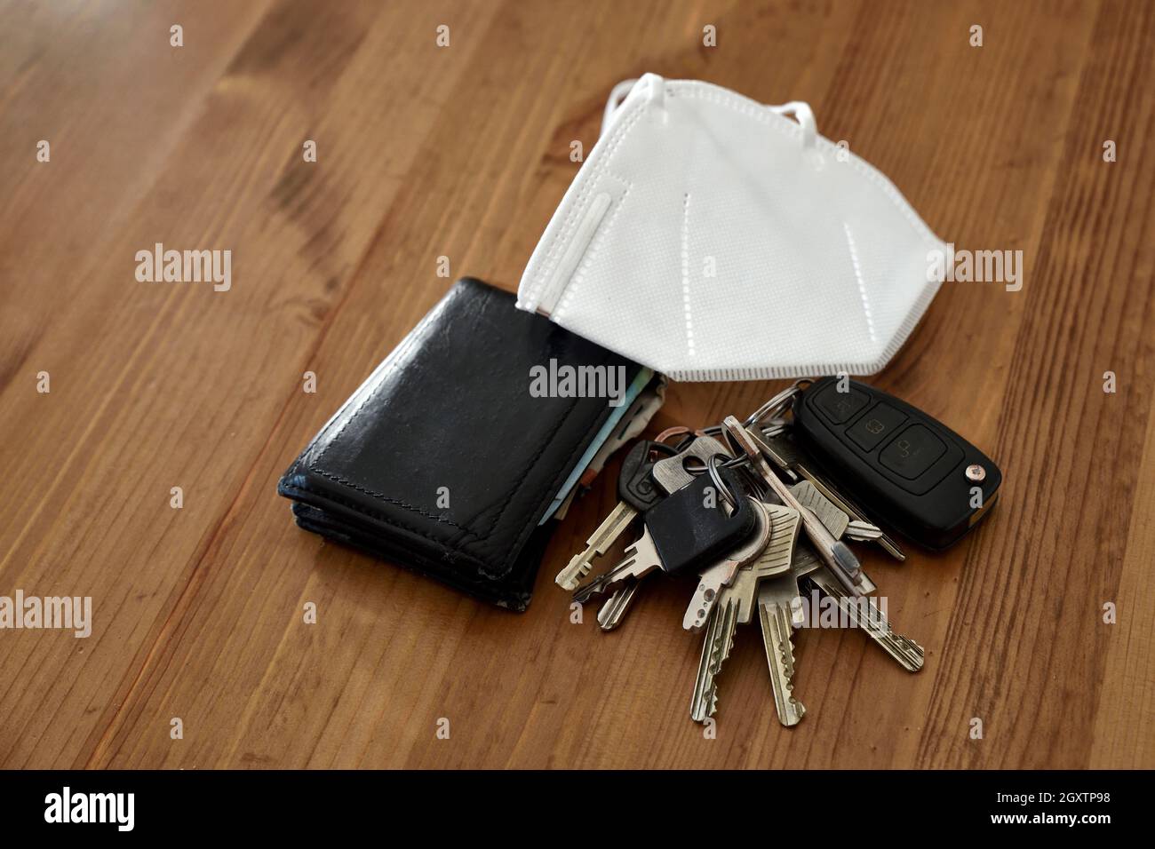 House and car keys, wallet, mobile phone and face mask on wooden surface.  Ready to go out in the new world Stock Photo - Alamy