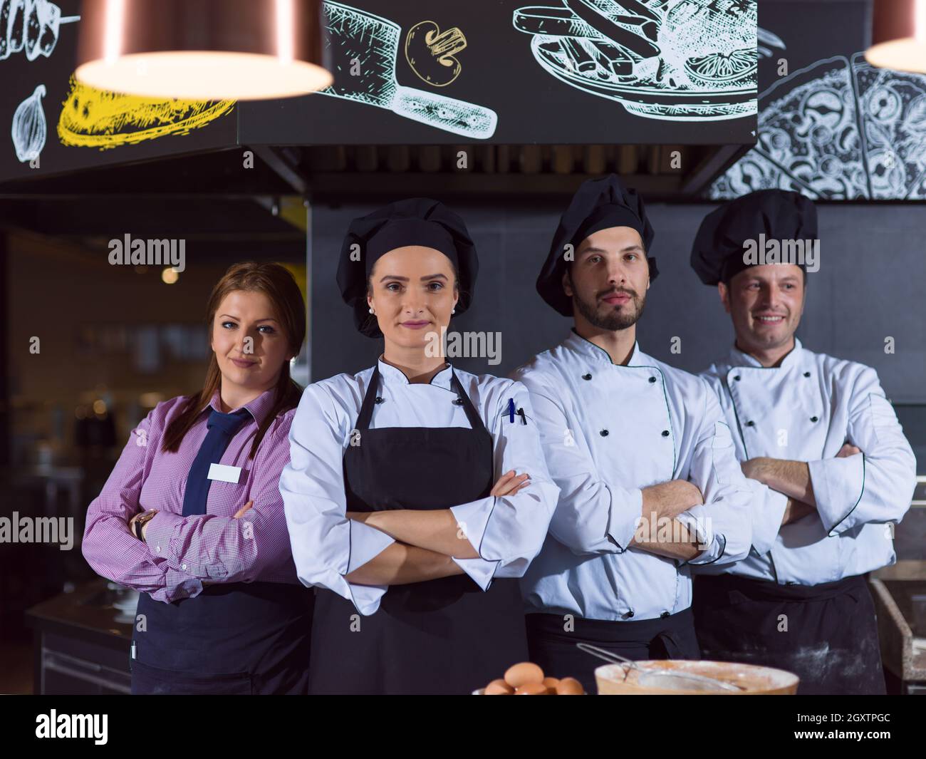 Portrait of group chefs standing together in commercial kitchen at ...