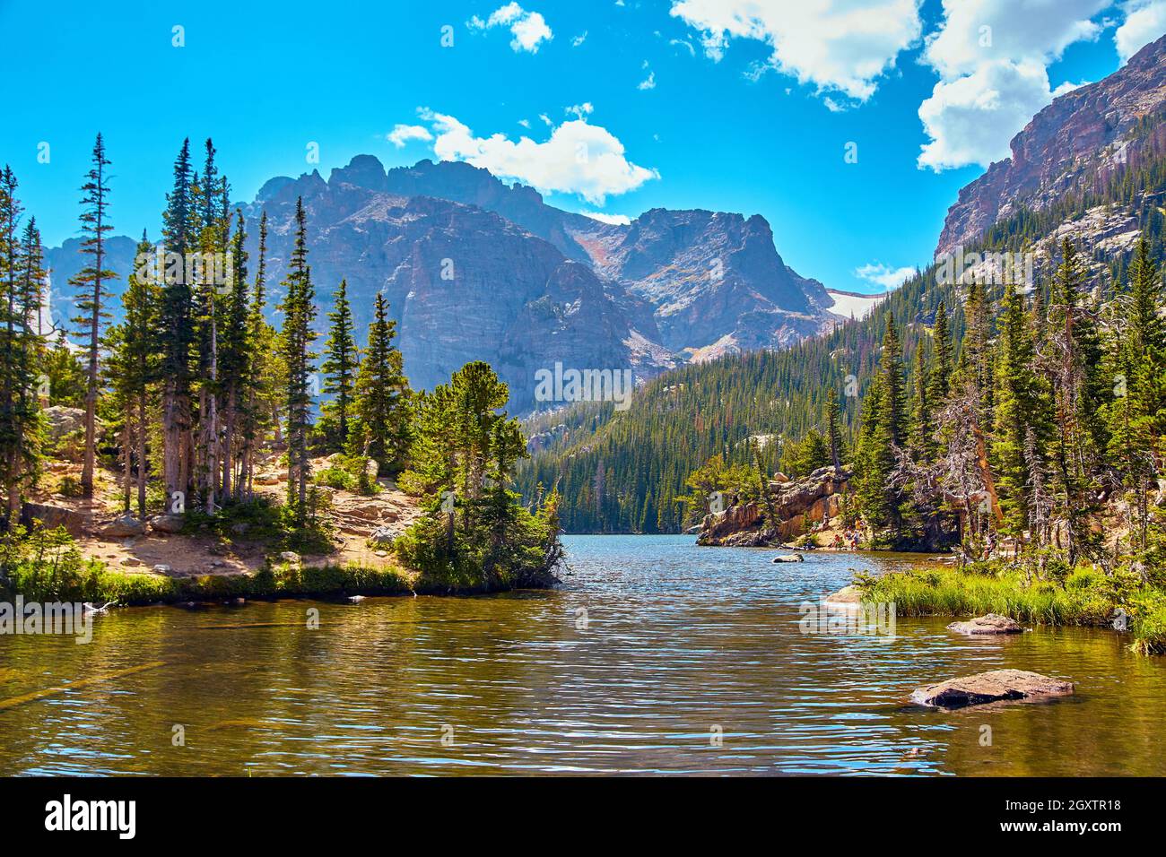 Lake in the mountains with pine tree island and blue sky Stock Photo ...