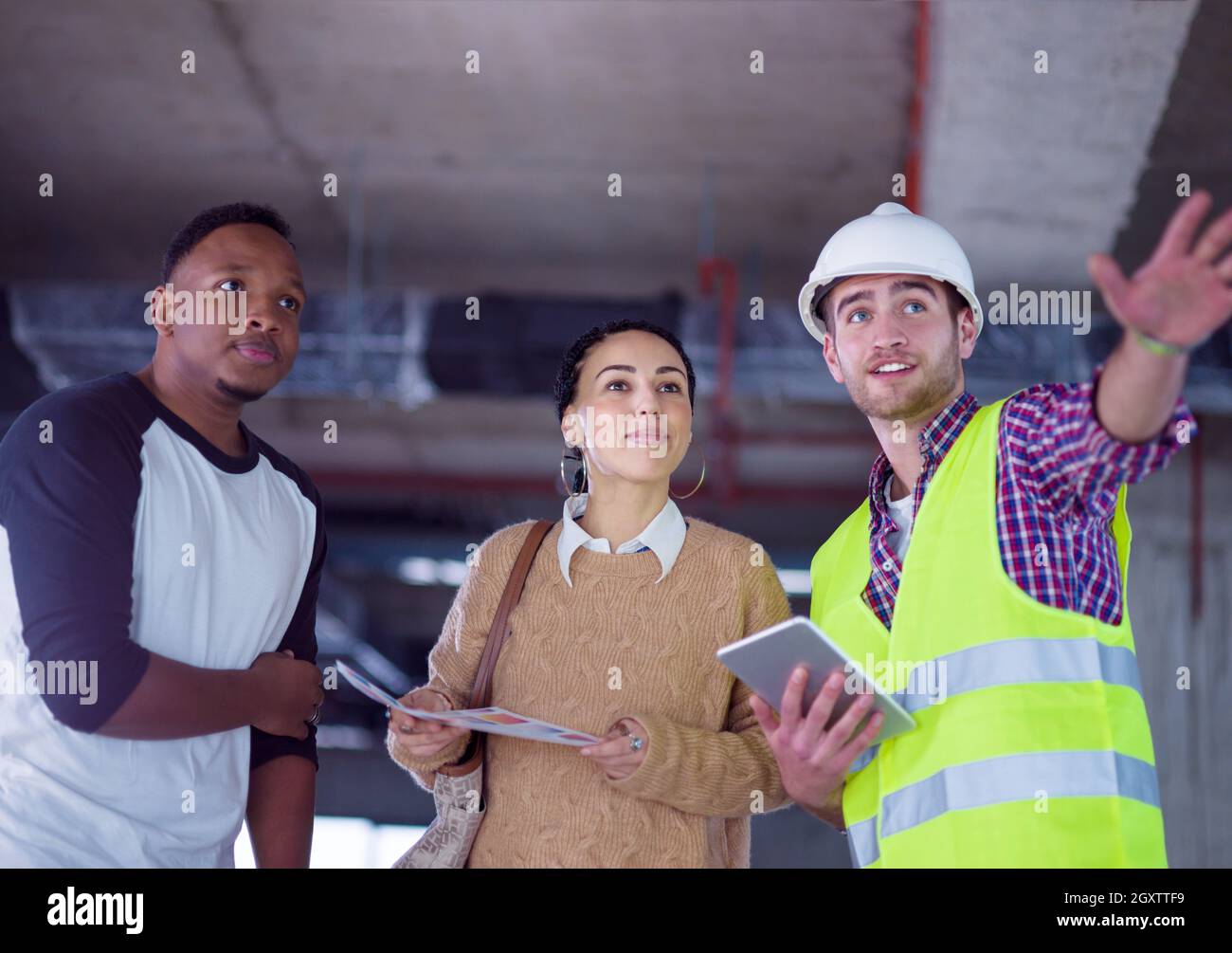 construction worker using tablet computer while showing house design ...