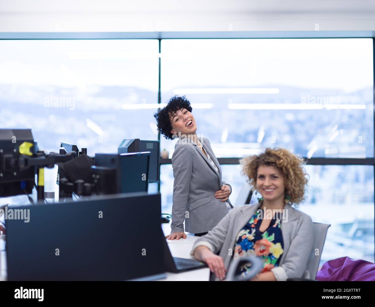 group of young female software developers using laptop and desktop computers while writing programming code at modern creative startup office Stock Photo